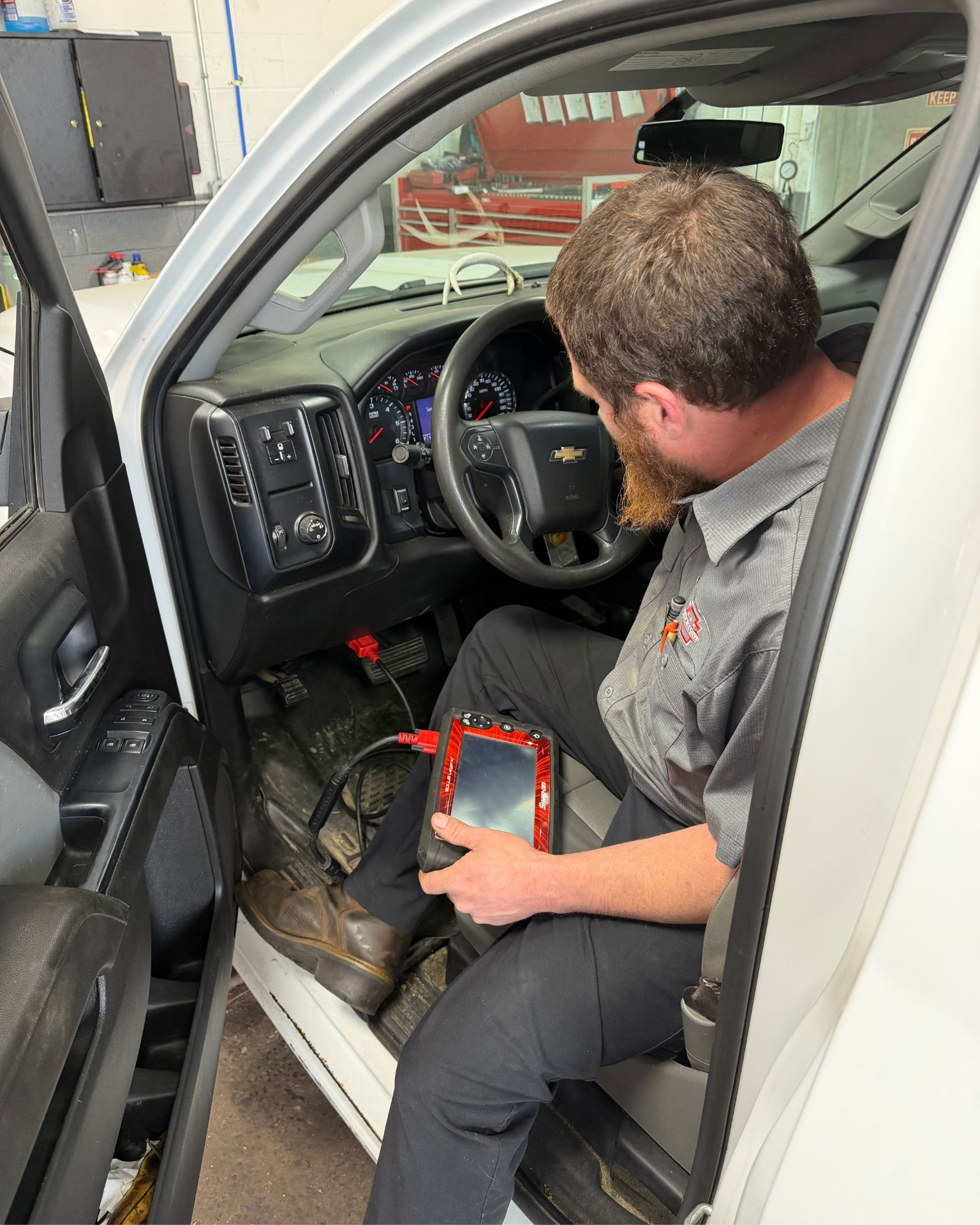 Technician performing engine diagnostics with a scan tool